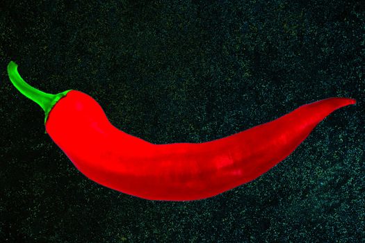 red pepper chile on black wall stone texture background