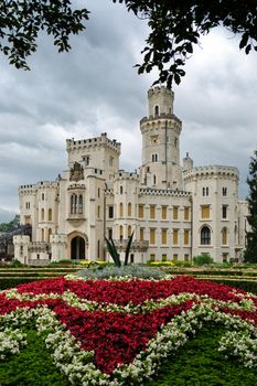 Old and white german castle with beautiful flower bed