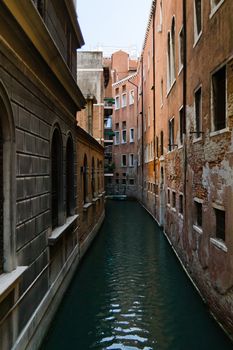 Venice narrow waterway with old houses on both sides