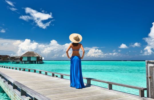 Woman on a tropical beach jetty at Maldives