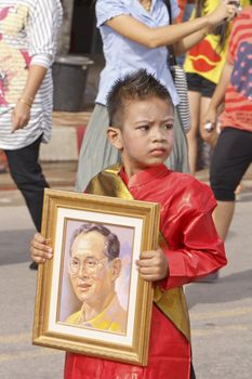 CHIYA, SURATTHANEE - JULY 13 : The unidentified Thai school children holding a picture of the kingr in Dogbua game parade on July 13, 2012 at Chiya, Surathanee, Thailand.