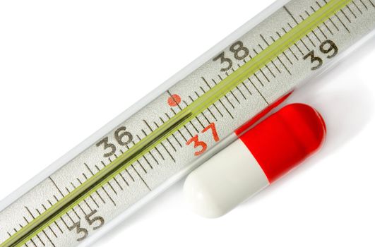 Thermometer with pill isolated on white background