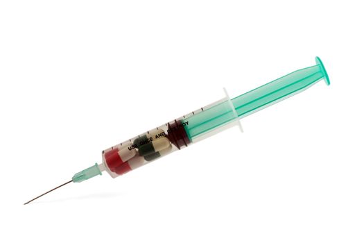 A syringe and an assortment of pills on white background