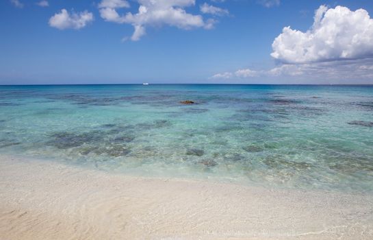 Caribbean sea: blue clear water with boat and blue sky with clouds