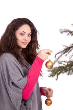 beautiful brunette woman is decorating a christmas tree isolated on white