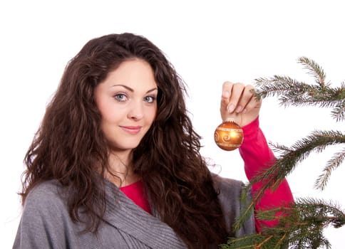 beautiful brunette woman is decorating a christmas tree isolated on white