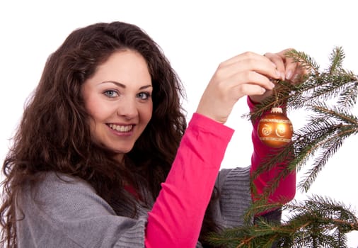 beautiful brunette woman is decorating a christmas tree isolated on white