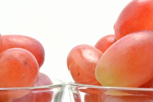Red grapes in glasses over white background