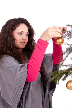 beautiful brunette woman is decorating a christmas tree isolated on white