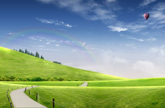 Landscape: country road among the hills with wood and hot air balloon flying in the sky where you can see the rainbow