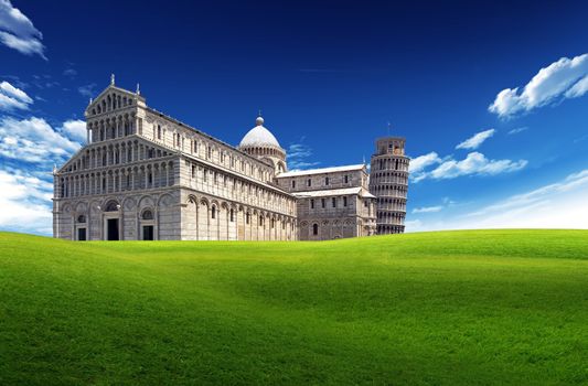 Country road with Pisa Cathedral and Tower, Italy, in the background with blue sky and clouds 