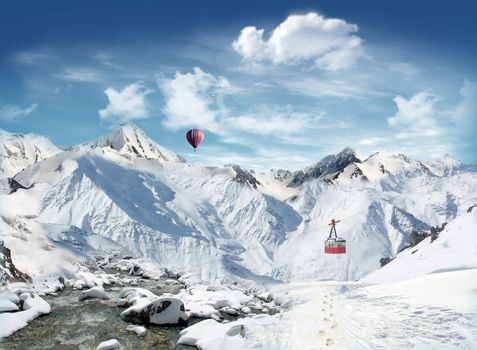 Footprint on the snowfield with stream and cabieway with mountains and hot air balloon flying in the blue sky in the background