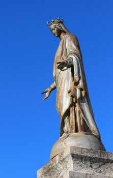 Notre Dame de Suize virgin statue, Grand-Bornand, France and blue sky. This statue is a metallic reproduction of the Virgin in Lourdes