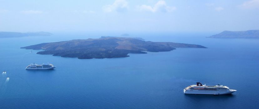 View on Santorini volcano and two cruise ships in the middle of Aegean sea, Cyclades, Greece, by beautiful weather