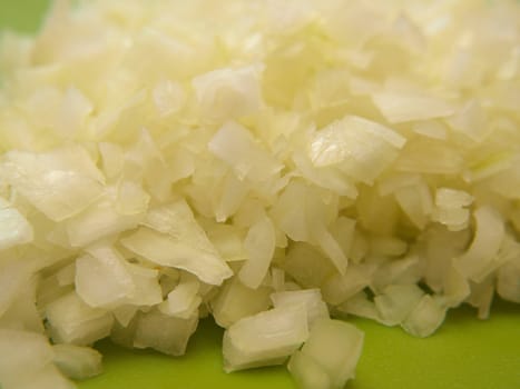 Closeup of freshly chopped onion, on chop board