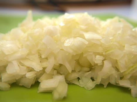 Closeup of freshly chopped onion, on chop board