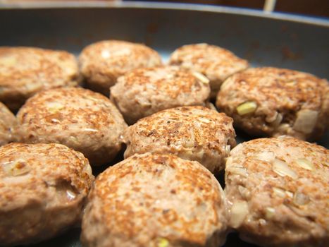 Frying many meatballs, isolated in a frying pan