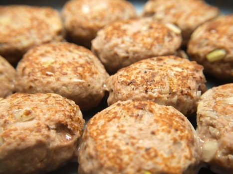 Frying many meatballs, isolated in a frying pan