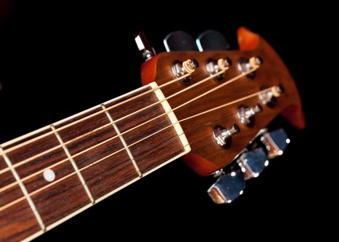 Macro shot down the fretboard of acoustic guitar with shallow depth of field