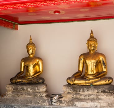Two golden buddha statues in Wat Po temple near Bangkok in Thailand