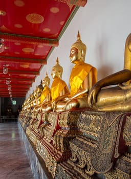 Many golden buddha statues in Wat Po temple near Bangkok in Thailand