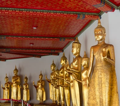 Many golden buddha statues in Wat Po temple near Bangkok in Thailand