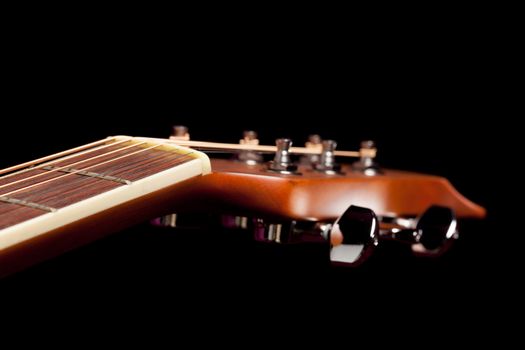 Macro shot down the fretboard of acoustic guitar with shallow depth of field