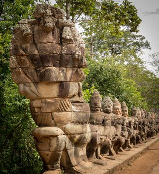 South gate to angkor thom in Cambodia is lined with warriors and demons