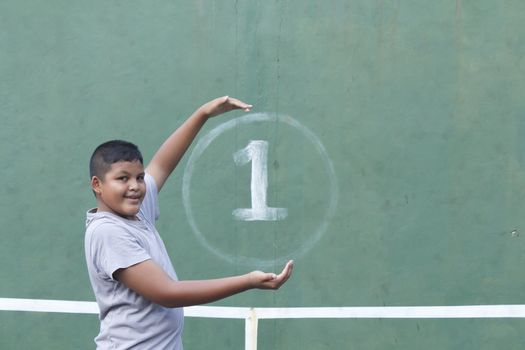 Boy action hold number one at tennis practice wall