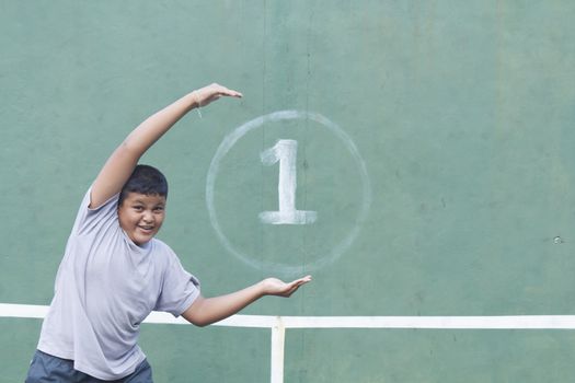 Boy action hold number one at tennis practice wall