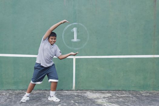 Boy action hold number one at tennis practice wall