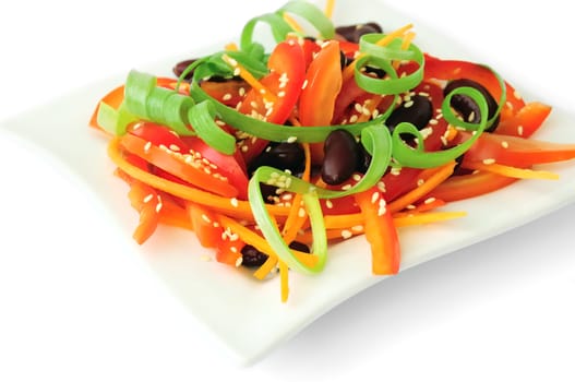 A salad of tomatoes, sweet peppers, red beans, carrots with sesame