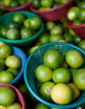 Green lemons  on sale in a food market in Thailand