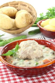 delicious cooked meatballs in a white sauce with capers, garlic and parsley