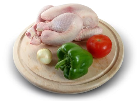 Whole raw chicken with vegetables and pepper