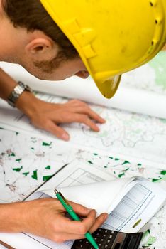construction worker calculating and checking documents, maps and charts