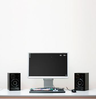 Computer system setup with speakers, monitor for video editing on a white desk
