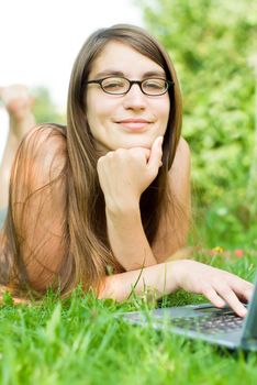 portrait of young woman surfing the internet outdoors on her notebook 