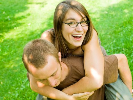happy young couple having fun outdoors doing piggyback rides