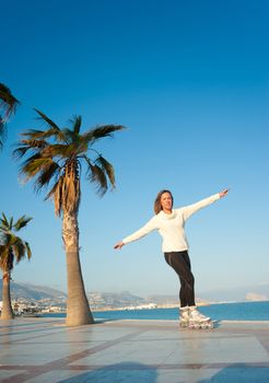 Having fun skating on a sunny Mediterranean beach promenade