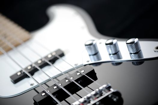 close up of a black electric bass glossy on dark background