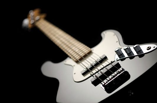 close up of a black electric bass glossy on dark background