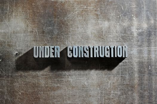 Image of a Under Construction sign with a metallic background texture