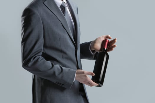 elegant man holding a bottle with a red wine