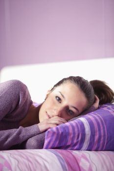 Closeup of a young woman lying on bed