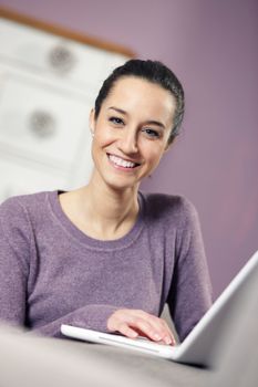 portrait of young woman on the sofa using laptop