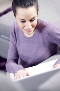 at home: young woman working on her laptop