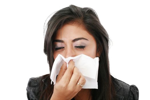 Pretty caucasian businesswoman blowing her nose in the office.