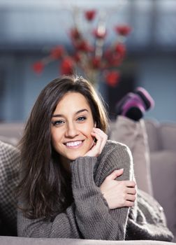 Portrait of a beautiful young woman lying on couch