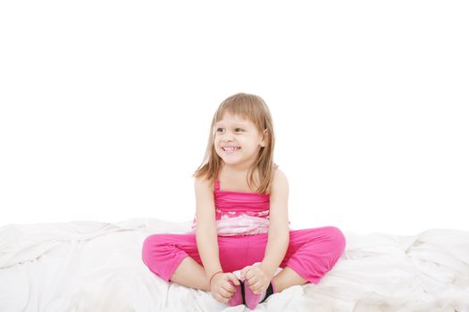 Portrait of a cute little girl sitting on floor, isolated over white